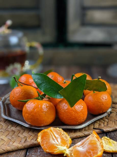 istock Fresh mandarin oranges fruit or tangerines with leaves on a wooden table 1634989384