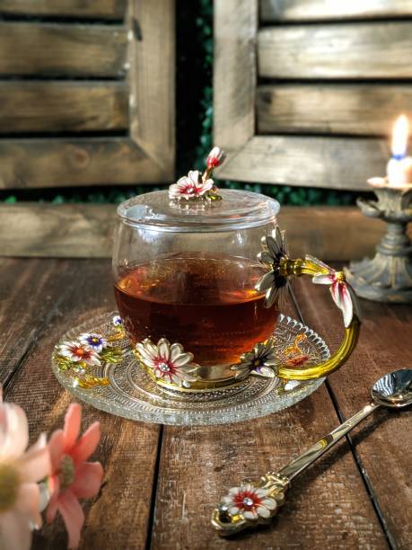 A Cup of freshly brewed black tea,escaping steam,warm soft light, darker background.