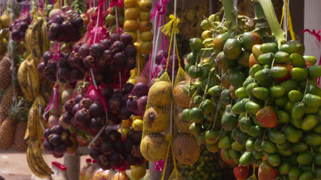 Close-up of typical fruits from the north of Brazil hanging from a street stall. colorful Brazilian regional fruits. Theme collection videos.