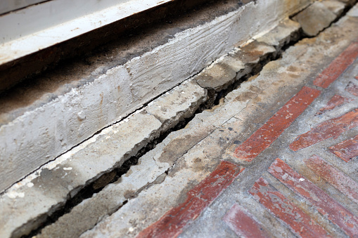 Home building problem. Cracked concrete floor, broken building structure