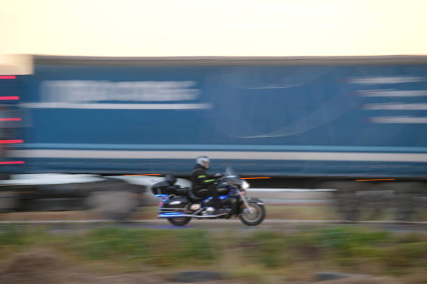 Full length profile shot of a biker riding a young woman on a chopper and showing thumbs up isolated on white background