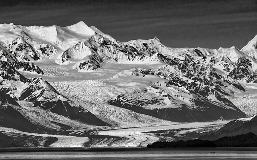 Magnificent mountains and flowing glaciers are captured in a stark and impressive black and white photo image