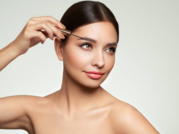 istock Beautiful woman puts mascara on her eyebrows 1635090381