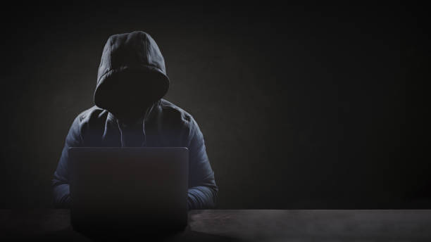 istock Hacker wear hood working with laptop. 1635108556