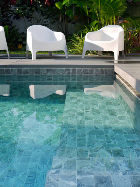 istock Modern design white plastic chairs at swimming pool side and outdoor garden, comfortable veranda decorated, wooden deck, back yard privacy space for rest and relaxation 1635119892