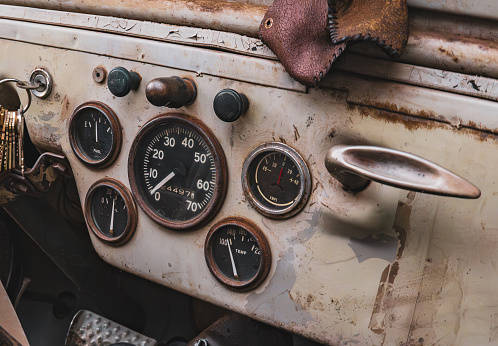 Dashboard dials of Korean War era vintage vehicle, slight sepia tone, rust and 70 years of wear.