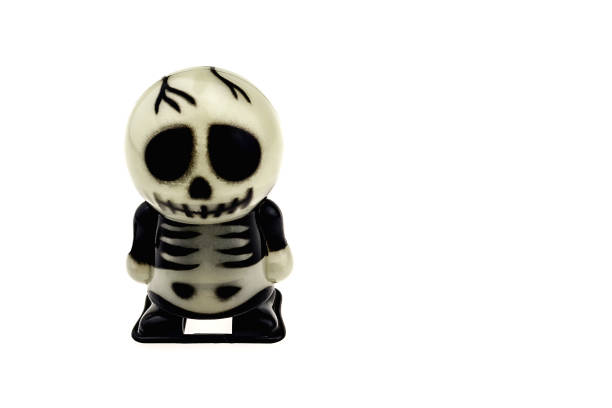 A creepy Halloween skeleton with it's arms outstretched as it look though fire with it's jaw open.