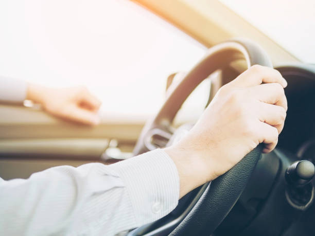 istock Close up of a man driving car using one hand, dangerous behavior 1635132670