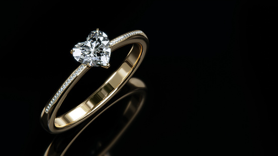 The gold diamond ring sits on a shiny black glass surface. heart shaped diamond ring design with 3d rendering.