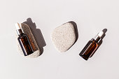Natural cosmetics in two bottles with a pipette lying on oval flat gray stones. A copy of the space. Design branding. empty packaging.