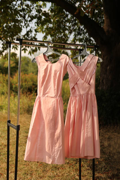istock Orange summer dresses hang on hangers. 1635196606