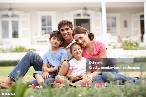 Familie Sitzt Auf Dem Rasen Vor Dem Haus Stockfoto und mehr Bilder von Familie - Familie, Hausgarten, Im Freien