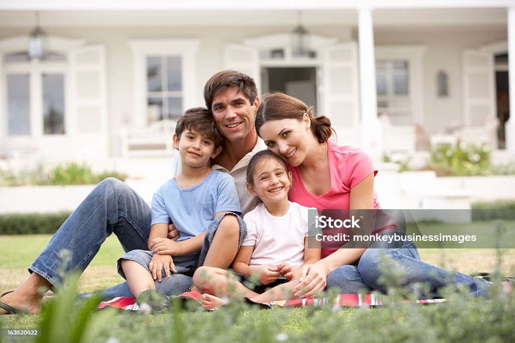 Rodzina siedzący na zewnątrz Dom na trawniku - Zbiór zdjęć royalty-free (Rodzina)
