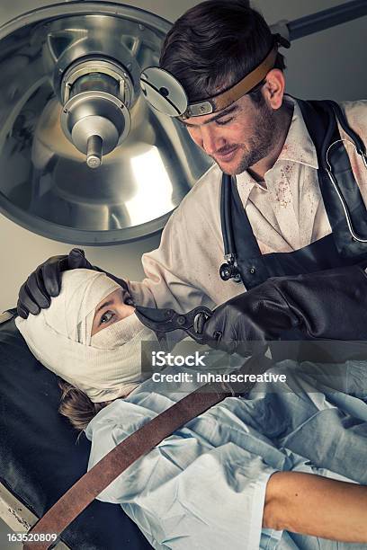 Evil Doctor Teasing Before Torturing Helpless Female Victim Stock Photo - Download Image Now