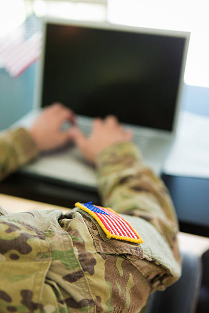 American Soldier typing on laptop stock photo