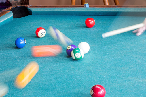 Man playing pool with balls moving and motion blur