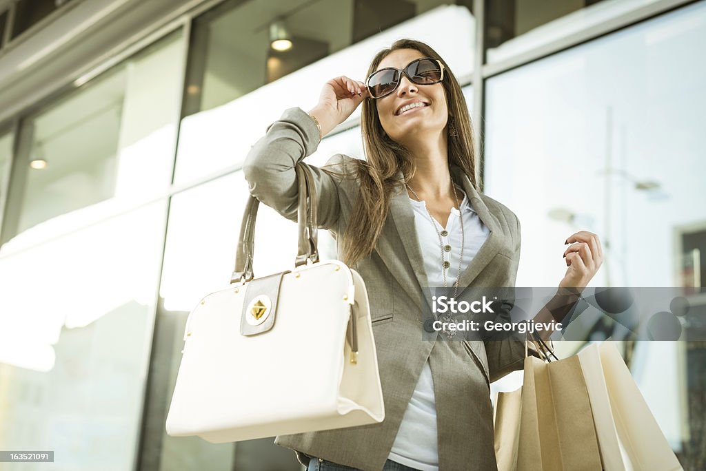 Smiling girl with shopping bags Female model in shopping, carrying a shopping bags and a purse. Luxury Stock Photo