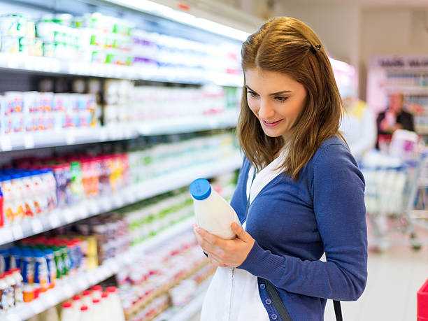 Female buying milk in supermarket stock photo