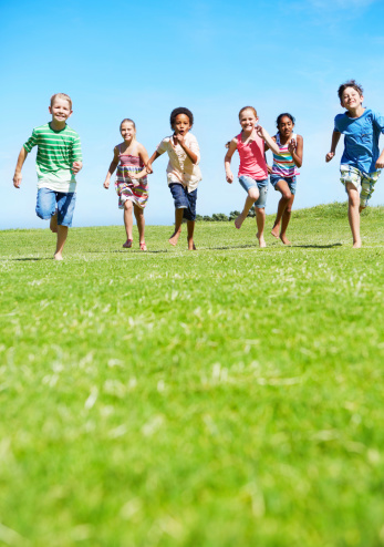 A group of children running on an open field