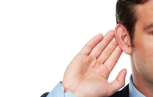 A businessman putting a hand to his ear to hear you better - Isolated