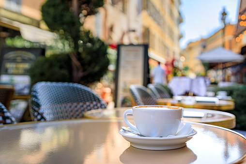 Cup of cappuccino at breakfast on an outdoor table at a bakery cafe in the old town or Vieille Ville in Nice, French Riviera, South of France