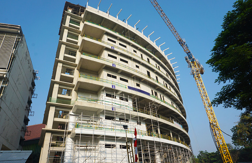 Curved building construcion facade in progress with tall crane