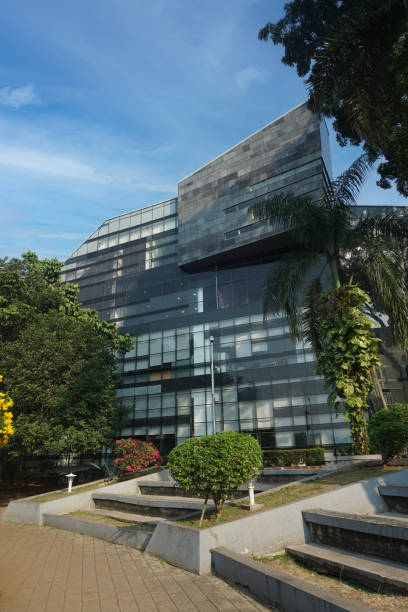 istock Modern eco-friendly glass architecture and greens against blue sky. 1635284987