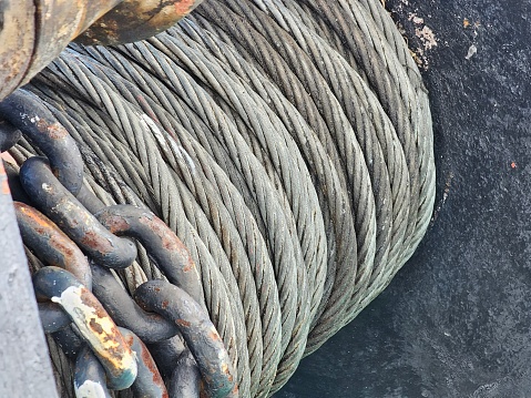 A weathered rope securely fastened to a wooden pole in a waterfront setting