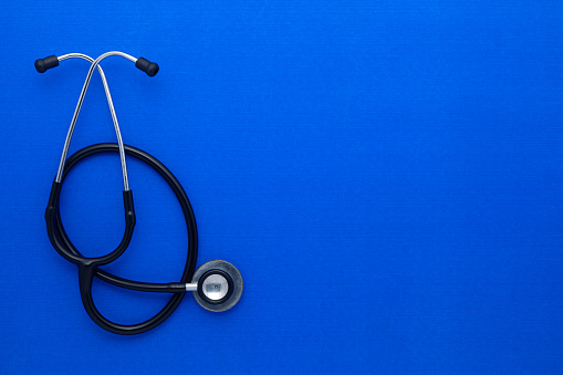 Medical stethoscope isolated on blue background. Flat lay, top view.