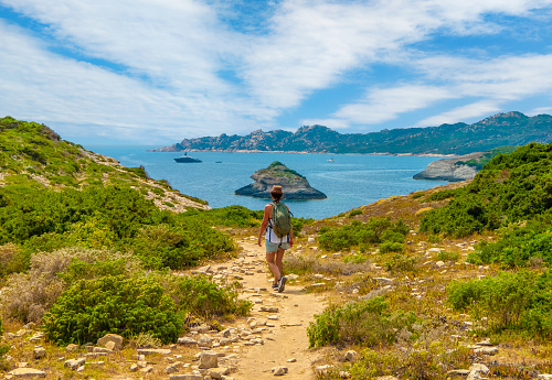 Corse, France - 29 June 2023 - Corsica is a big touristic french island in Mediterranean Sea, beside Italy, with beautiful beachs and mountains. Here in particular the town of Bonifacio with the Plage de Fazzio and girl tourist