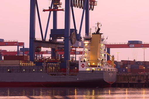 Containererschip is charged at dusk, at Container Terminal Altenwerder, Hamburg harbor, Germany