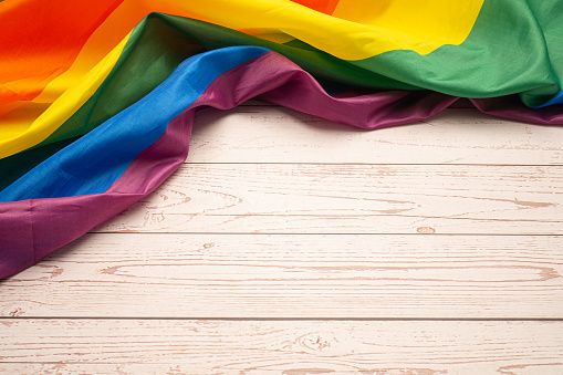 Pride month. The top view of the rainbow flag or LGBT is on a wooden table. Space for text. Flat lay