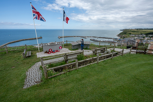 Port-en-Bessin-Huppain, France - 07 24 2023: View of the harbor, teh sea the D-Day Oil Port Memorial from the top of the cliff