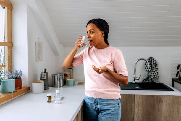 istock Casually clothed woman taking medicine in a domestic kitchen 1635386573
