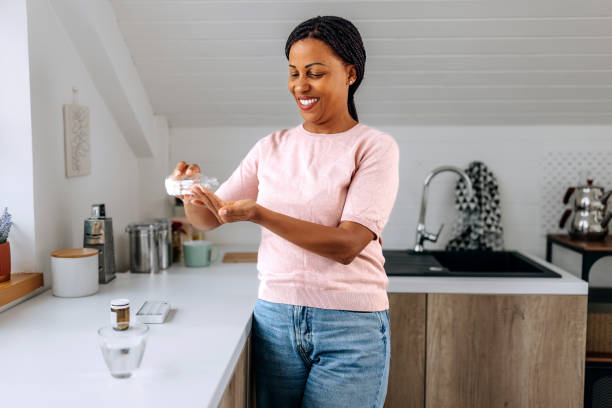 istock Casually clothed woman taking medicine in a domestic kitchen 1635386574