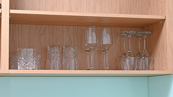 Different types of glasses on a shelf in the kitchen