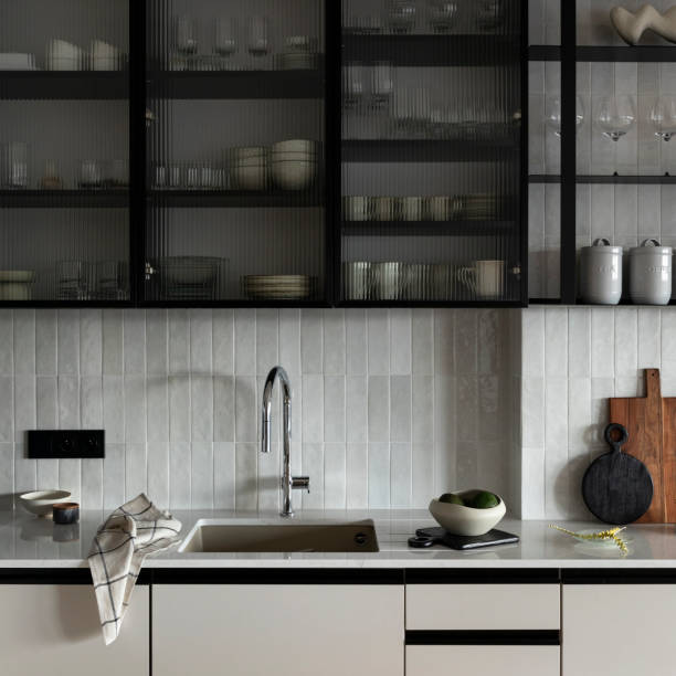 istock Modern composition of dining space with design kitchen island, modern furnitures, kitchen stuff, beige cup of coffee and elegant personal accessories. Stylish home decor. Template. 1635405224