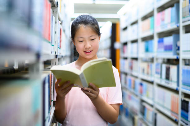 istock Asian junior high school student borrowing books in public library 1635405807