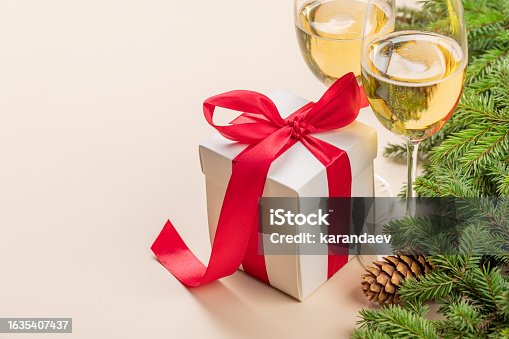 istock Xmas fir tree branch, Christmas gift box, champagne and space 1635407437