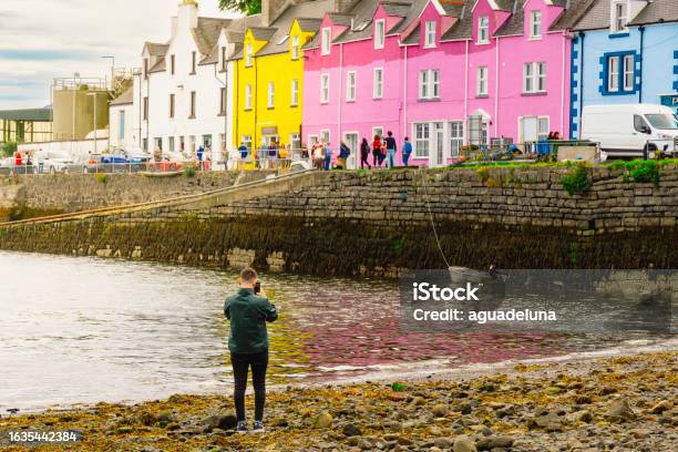 Unrecognisable Young Man Taking A Photo With A Smartphone Of The Colourful Houses At Portree Scotland Stock Photo - Download Image Now