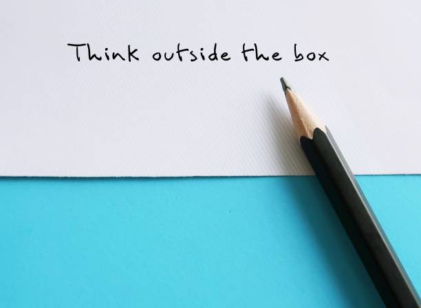 istock Paper on blue background with text written by pencil THINK OUTSIDE THE BOX , concept of breaking status quo to find innovative solution or create something differently, stand out from the crowd 1635447621