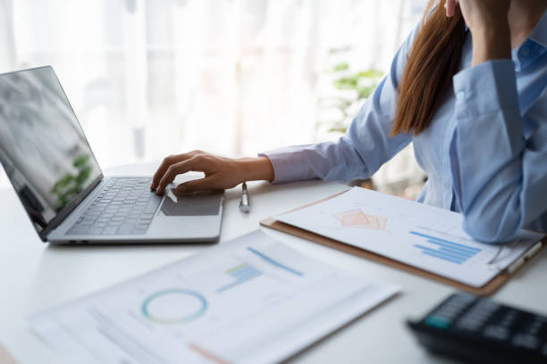 istock Asian businesswoman sitting and thinking analyze financial reports Business growth using laptop computer and documents, graphs, charts, investment calculators. Office business plan 1635450332