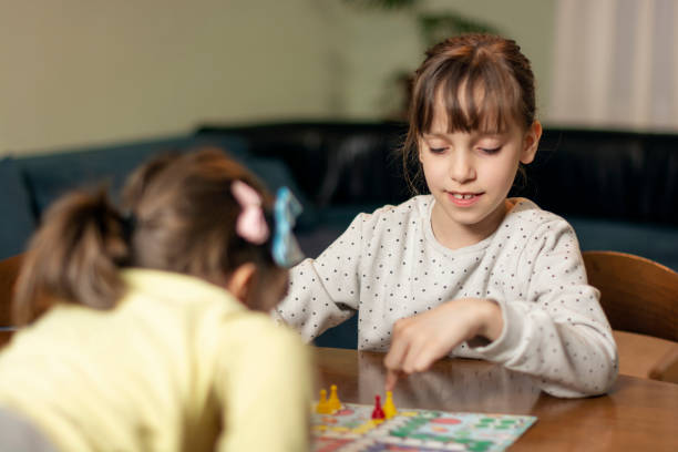 istock Two small girls playing board game at home 1635453027