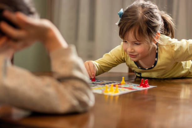 istock Two small girls playing board game at home 1635453605
