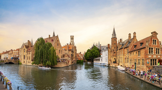 Bruges, Belgium - June 27, 2023: Rosary Quay in Bruges. General view of the old historic and touristic city of Belgium, Bruges medieval bell tower and historic houses from the water canal in summer.