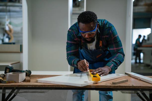 istock Afro American craftsman working as carpenter in a carpentry workshop. 1635494820