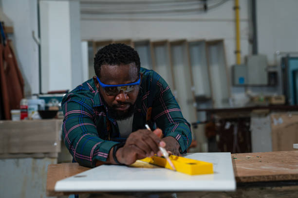 istock Afro American craftsman working as carpenter in a carpentry workshop. 1635496946