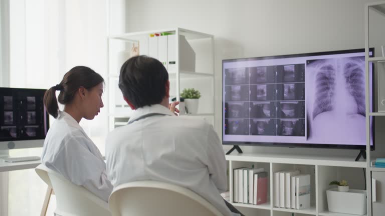 Two medical neurologists in the hospital meeting room analyzed the patient's X-ray film.