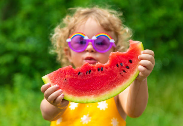 istock A child eats watermelon in the park. Selective focus. 1635537216