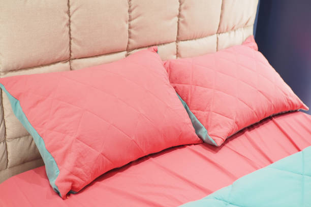 istock pink color pillow lined up on bed 1635549619
